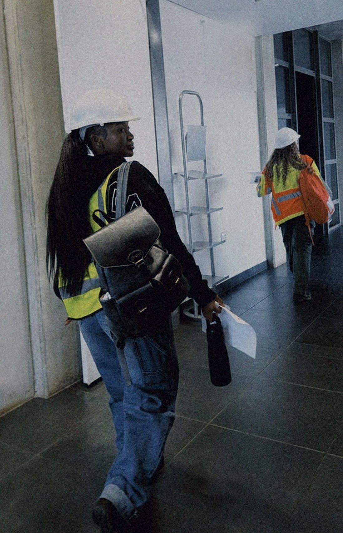 Facilitator in a hard hat and hi-vis vest walking through a training facility